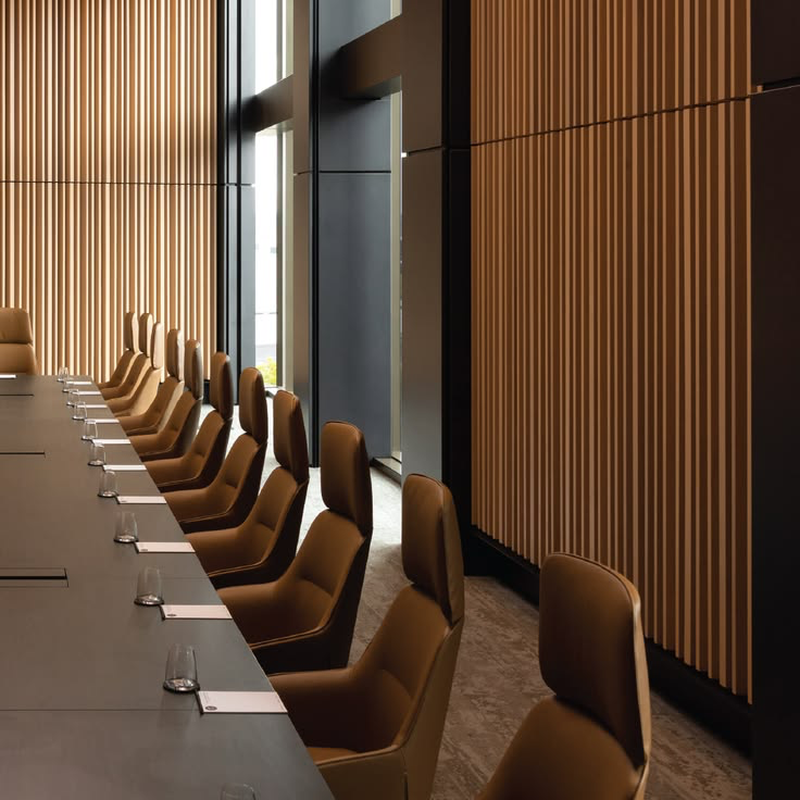 An elegant boardroom with a long conference table and leather chairs