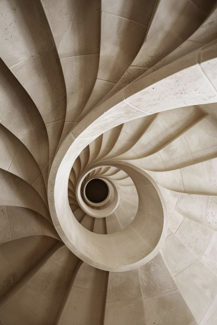 An elegant cream stone spiral staircase viewed from above
